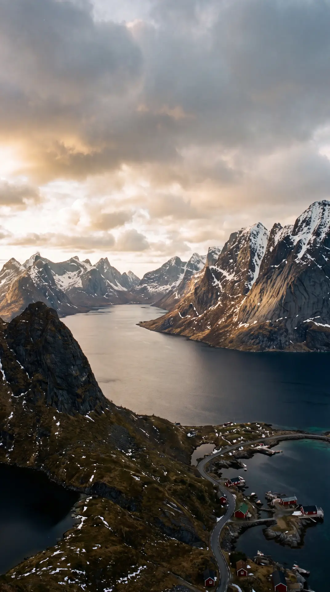 Dramatic fjord valley with snow-capped peaks and a winding coastal road